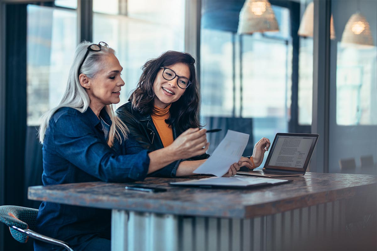 two women analysing documents while sitting